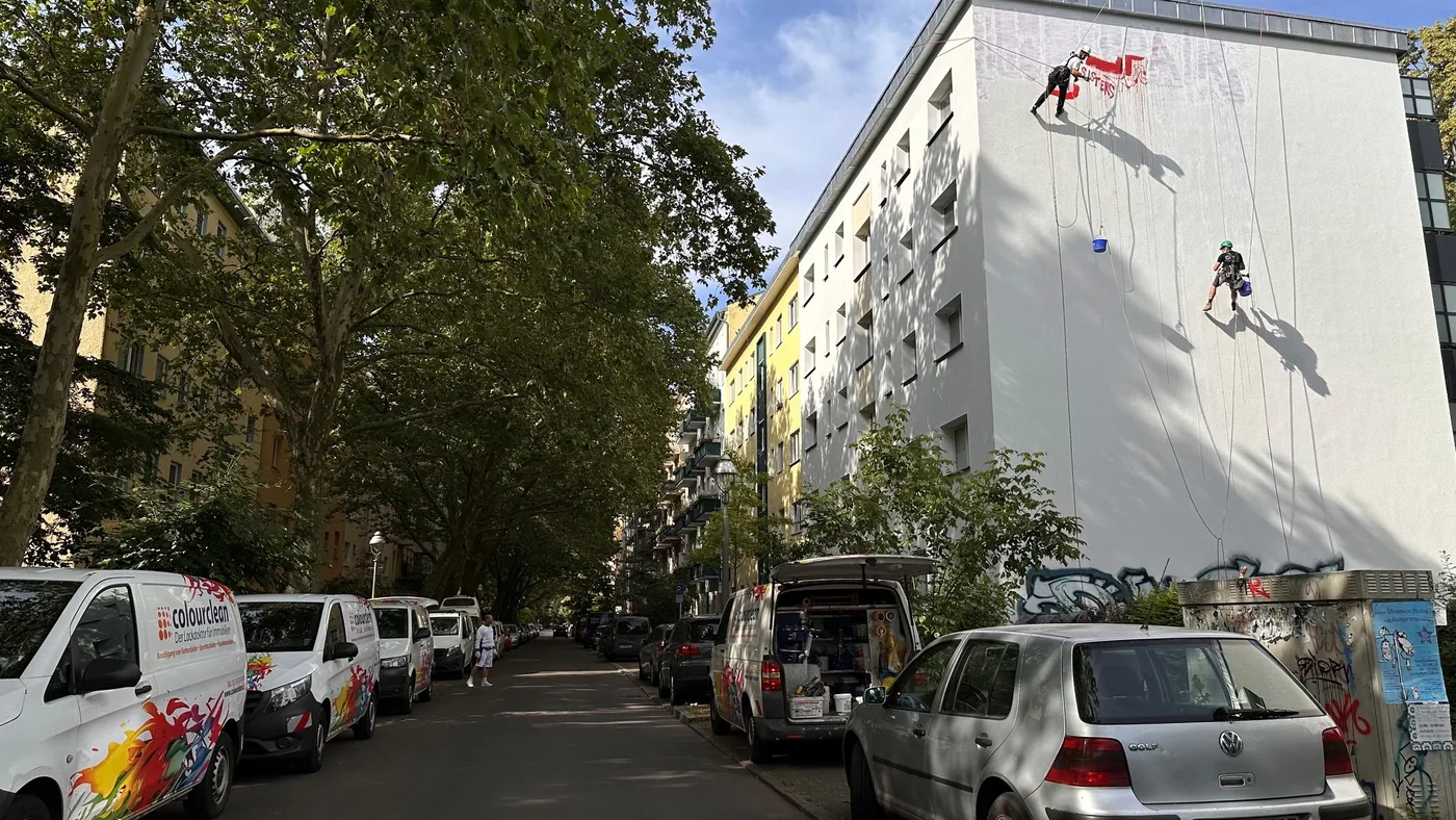 Gesamtansicht des Gebäudes mit Seilkletterer an der Fassade