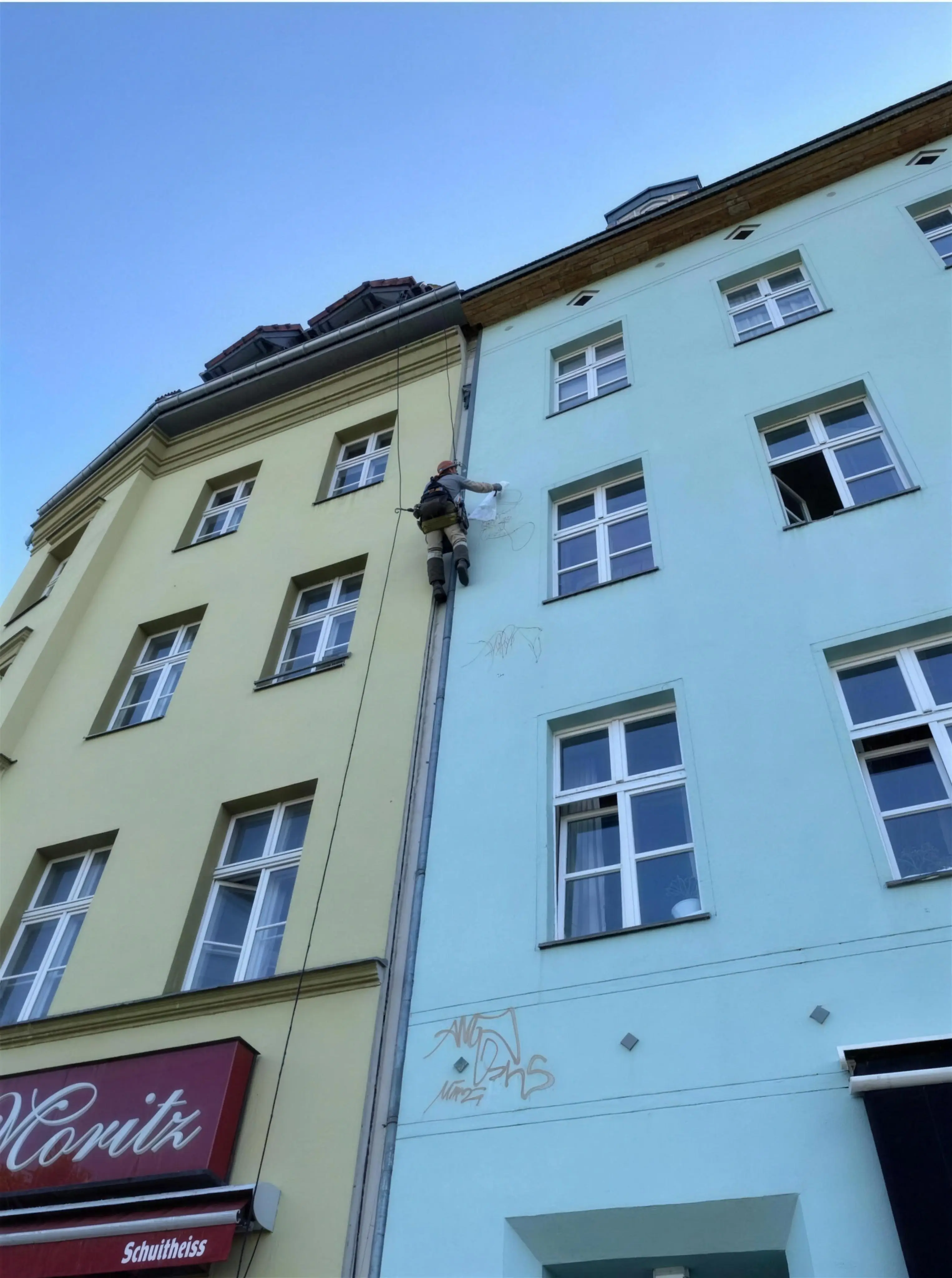 Fassadenreinigung Berlin – Colourclean-Mitarbeiter im Einsatz mit der Seilklettertechnik an einer Berliner Altbau-Fassade