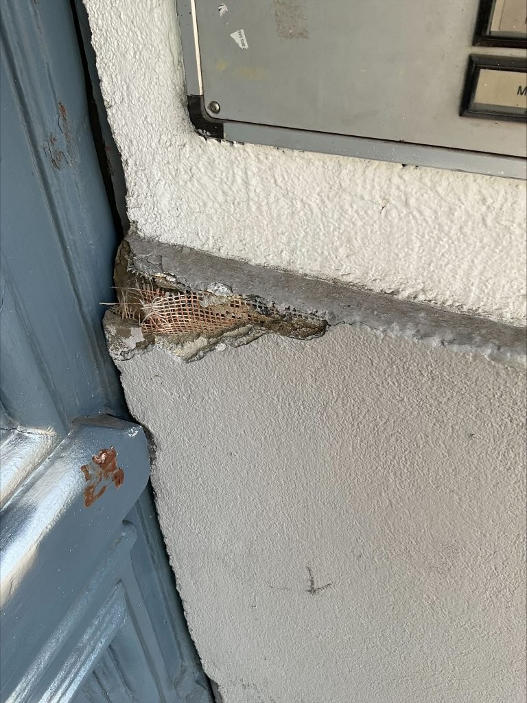 Maler bei einem kleinen Renovierungsauftrag in Berlin mit Ausbesserungsarbeiten an der Wand