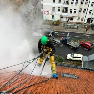 Industriekletterer bei Graffitientfernung auf Berliner Altbaudach mit Seiltechnik
